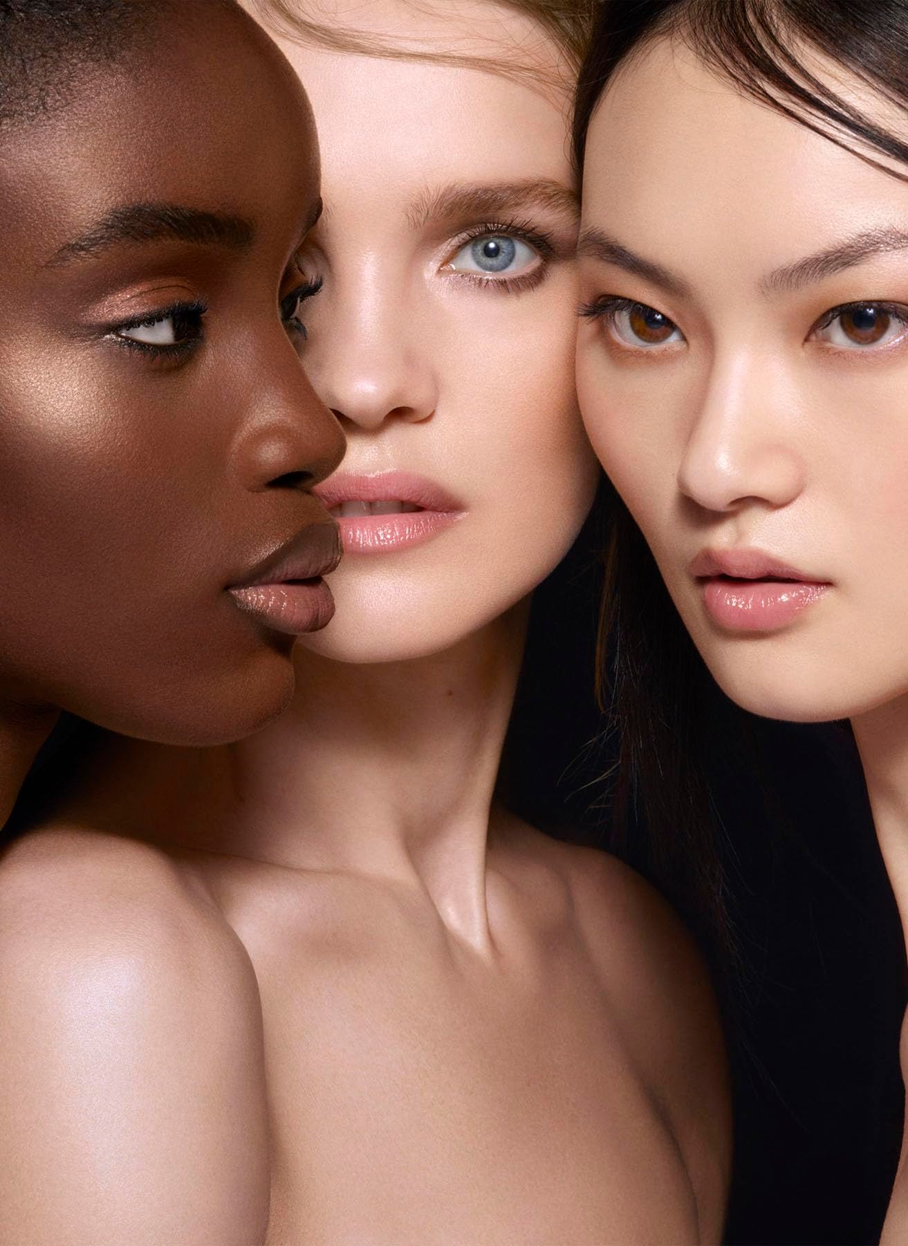 Tre volti di diversi colori della pelle. Primo piano. Pelle nera, chiara e asiatica.