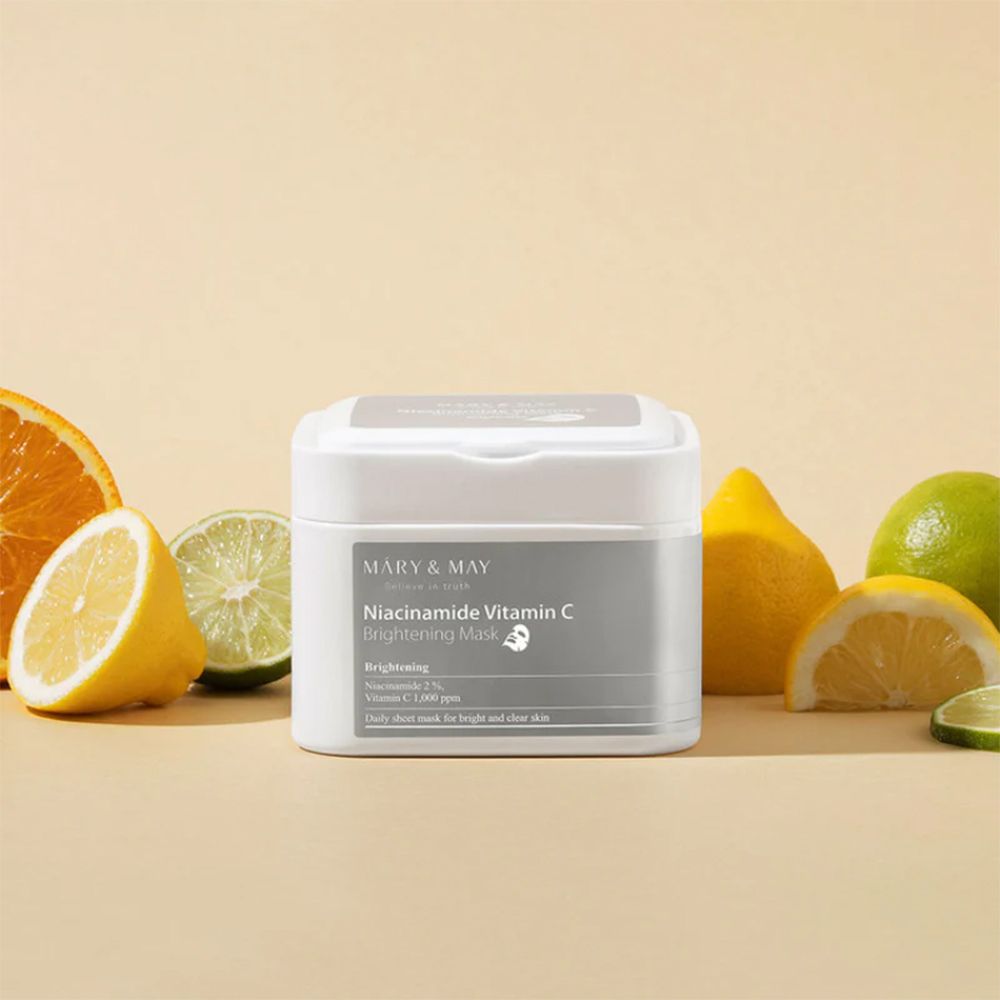 Contenitore bianco MARY & MAY Niacinamide Vitamin C Brightening Mask. Agrumi intorno al contenitore.