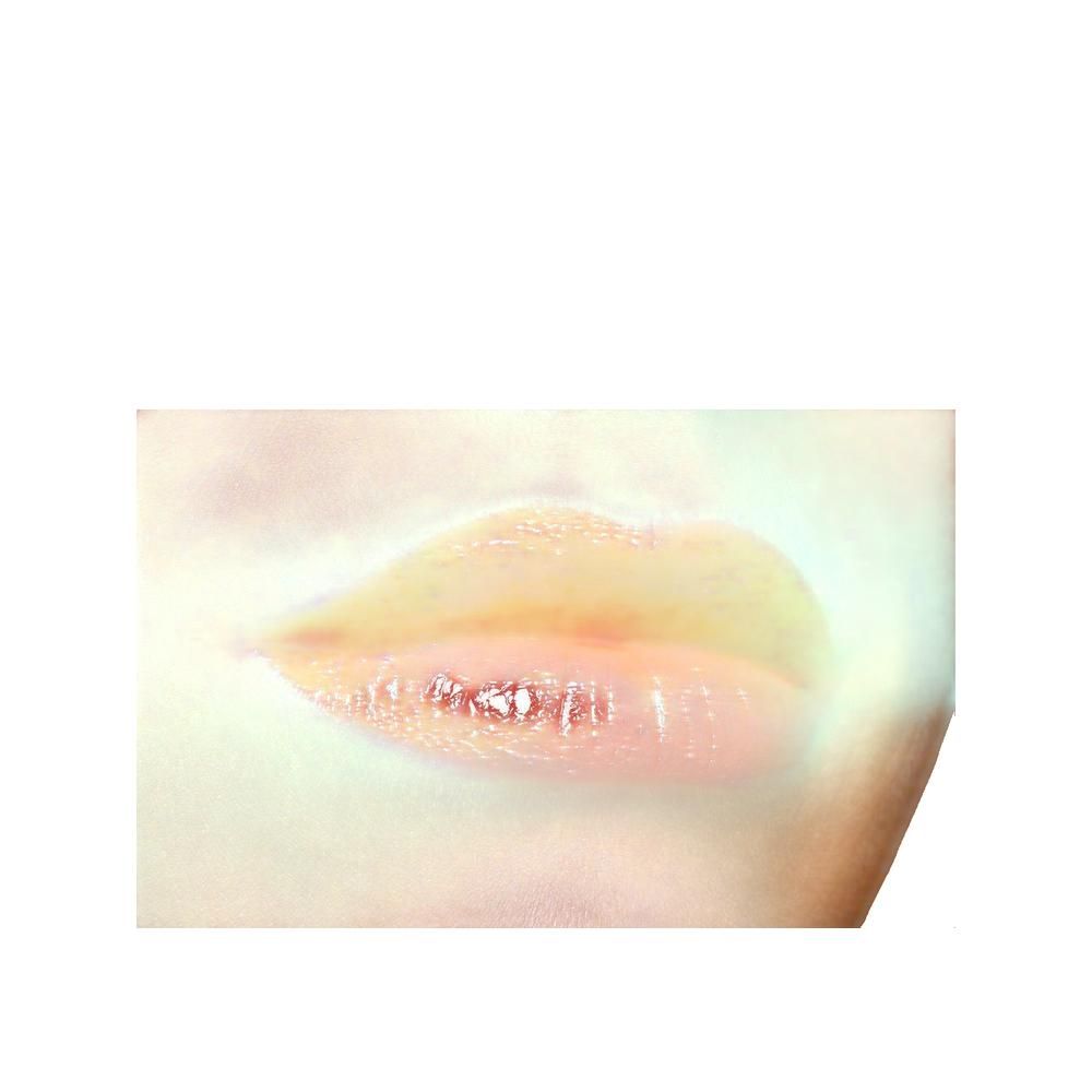 Primo piano di labbra lucide, rosa chiaro. Pelle sfocata sullo sfondo.