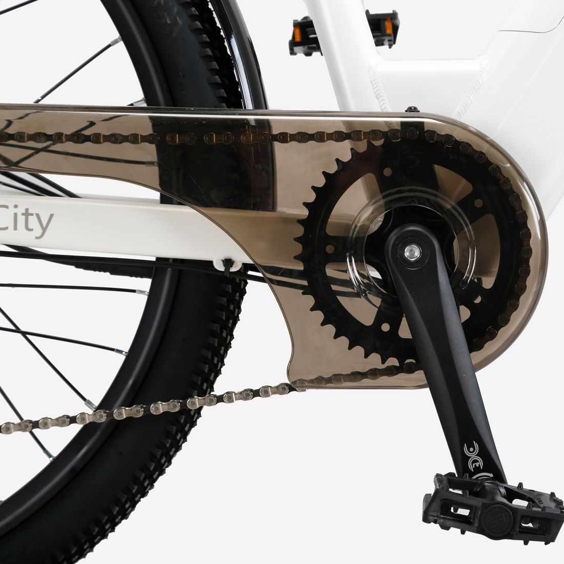 Primo piano della bicicletta elettrica. Catena, pedali e corona visibili.