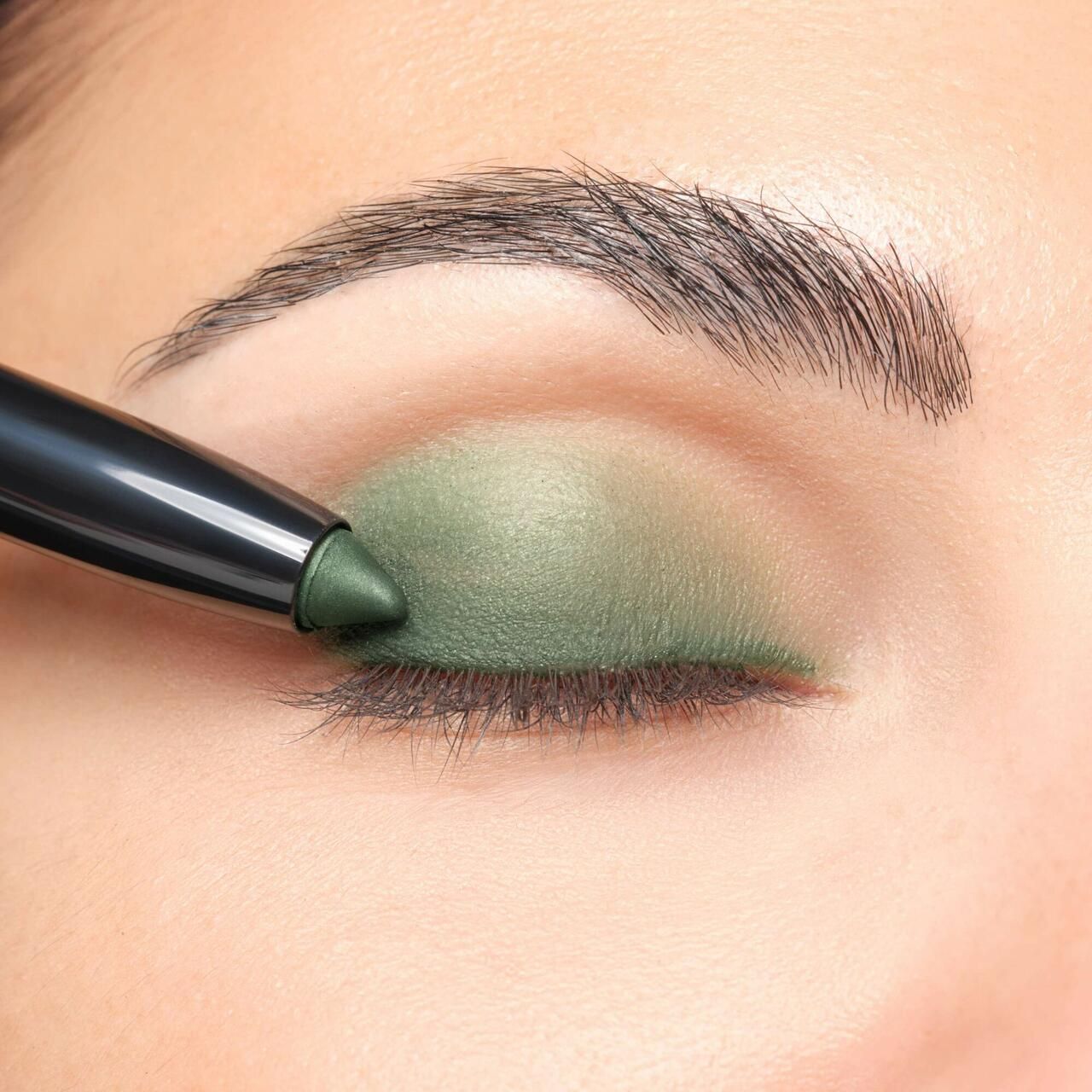 Artdeco High Performance Eyeshadow Stylo applicato sulla palpebra. Ombretto verde. Matita nera.