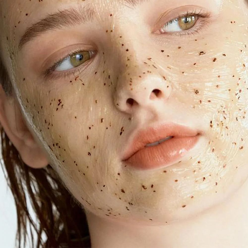 Primo piano del viso di una donna con una maschera viso gelatinosa e granulosa.