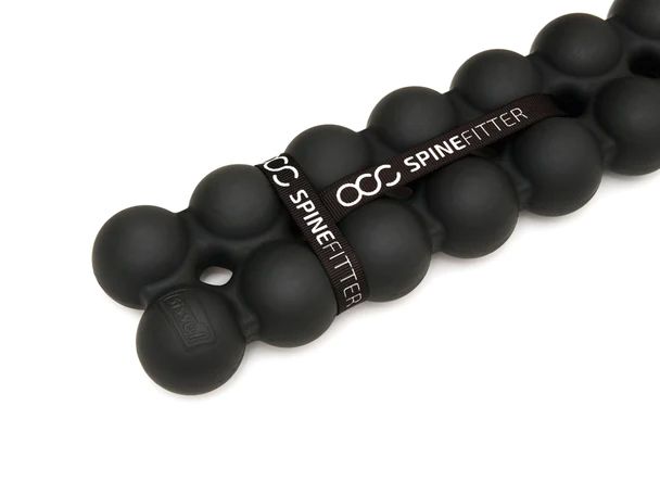 Primo piano di un SISSEL Spinefitter nero. Elementi rotondi collegati da una fascia con la scritta SPINEFITTER.