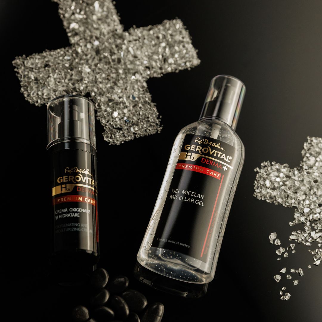 Due flaconi, uno nero, uno trasparente, accanto a una decorazione a forma di croce di vetro e pietre. Scritta: Gerovital H3 Derma+ Premium Care.