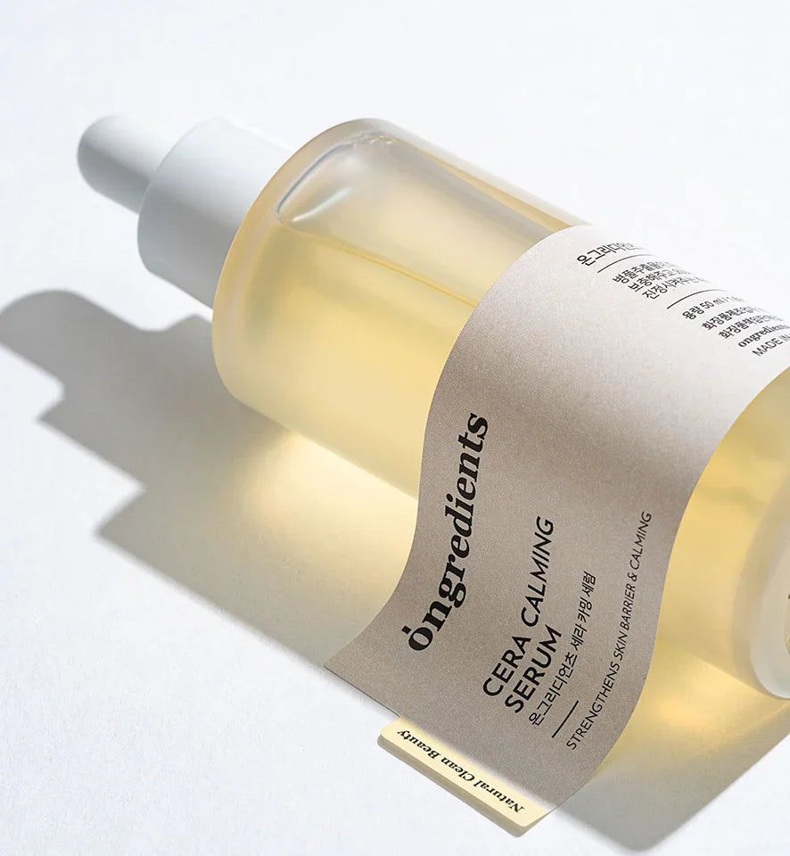 Flacone di siero con contagocce. Scritta: Ongredients Cera Calming Serum. Etichetta con testo. Ingredienti naturali.