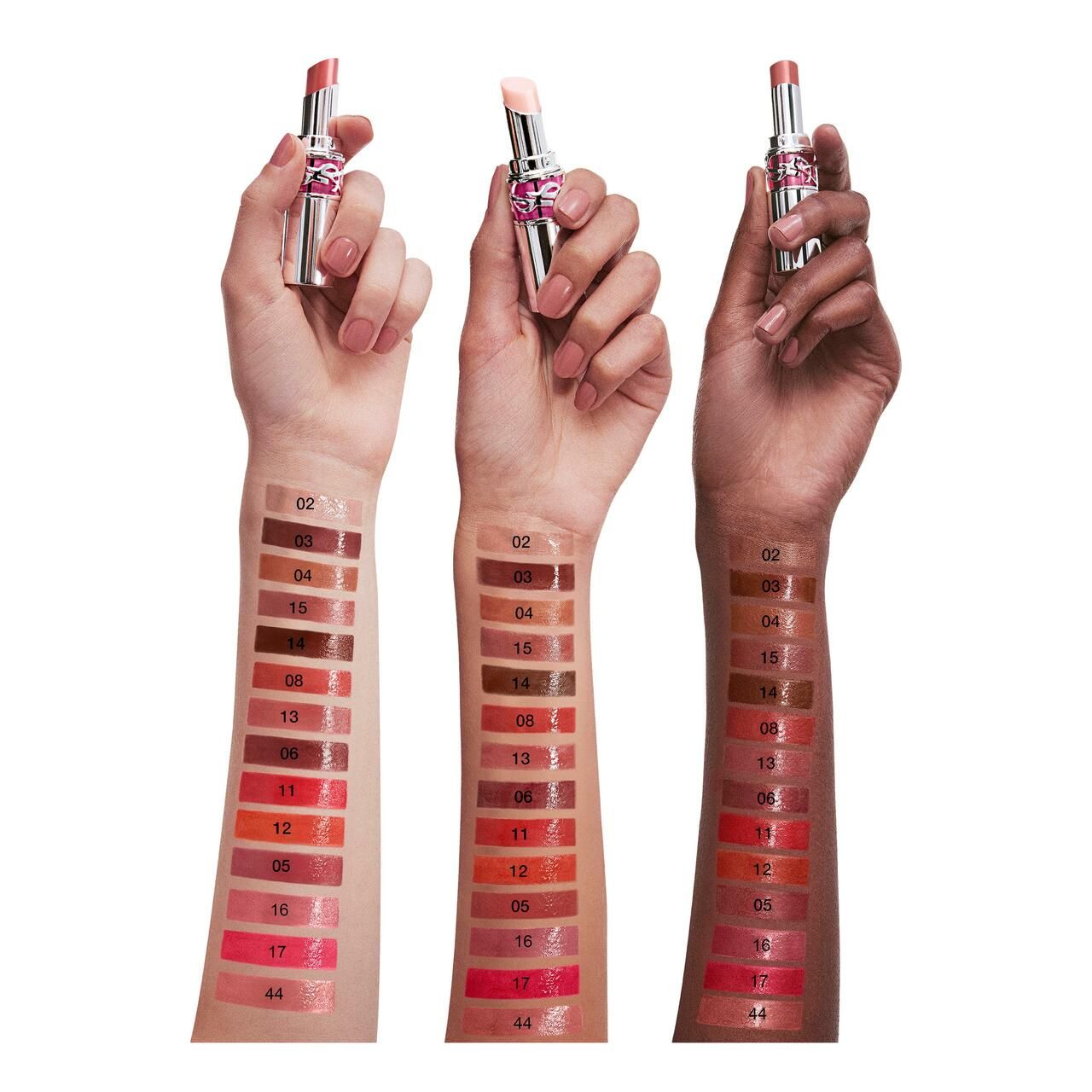 Tre braccia con campioni di rossetto. Diverse tonalità della pelle. Rossetti con custodie argentate.