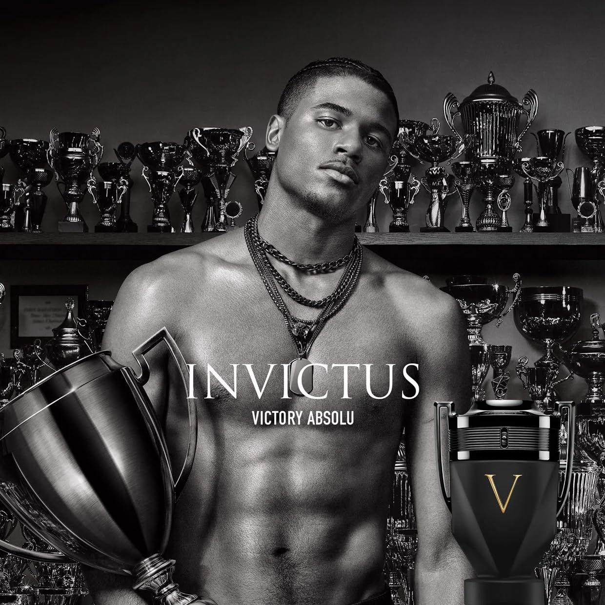 Uomo a torso nudo, con flacone e trofei. Scritta: Invictus Victory Absolu.