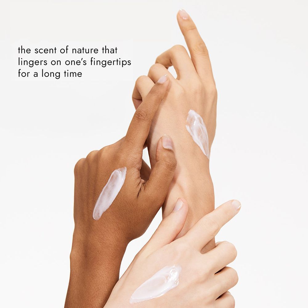 Mani con crema. Applicata su due mani. Testo: Il profumo della natura che indugia a lungo sulle dita.