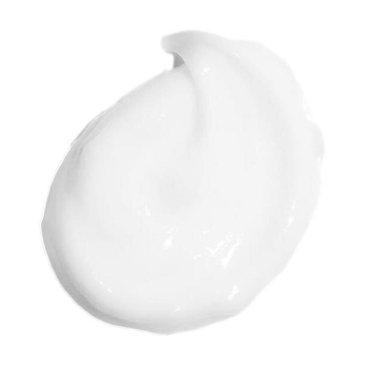 Macchia di crema bianca su sfondo bianco. Texture liscia, leggermente lucida.