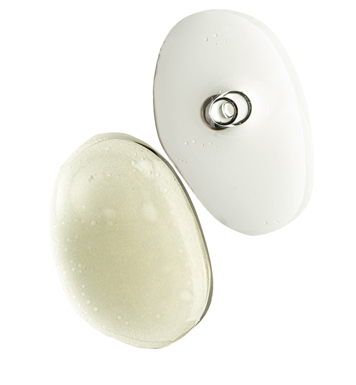 Due applicatori ovali bianchi. Anello metallico in alto. Liquido visibile. Sfondo bianco.