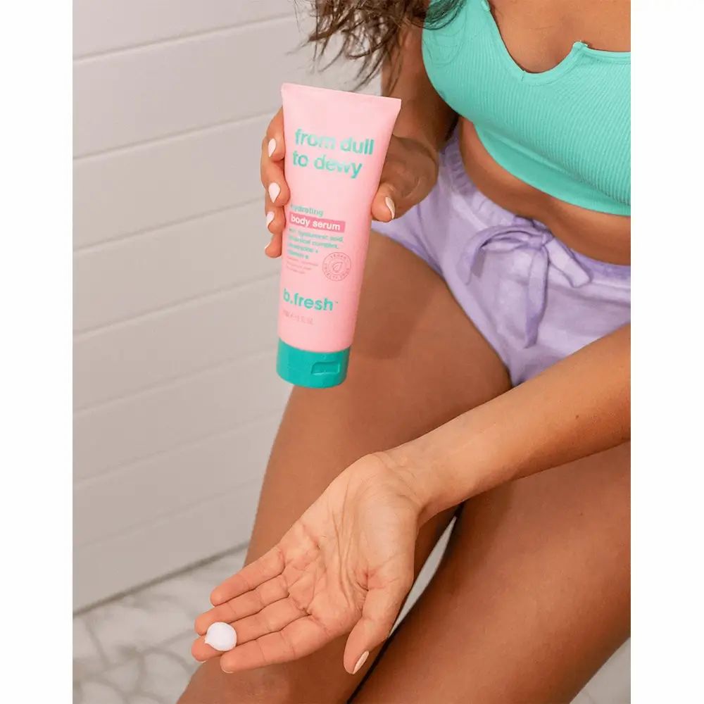 Tubo rosa con tappo verde. Scritta: From Dull To Dewy. Persona tiene il tubo e il siero in mano. Logo B.fresh.