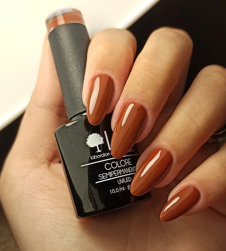 Mano con unghie smaltate e flacone di smalto. Scritta: LCI, COLORE SEMIPERMANENTE, UVLED.