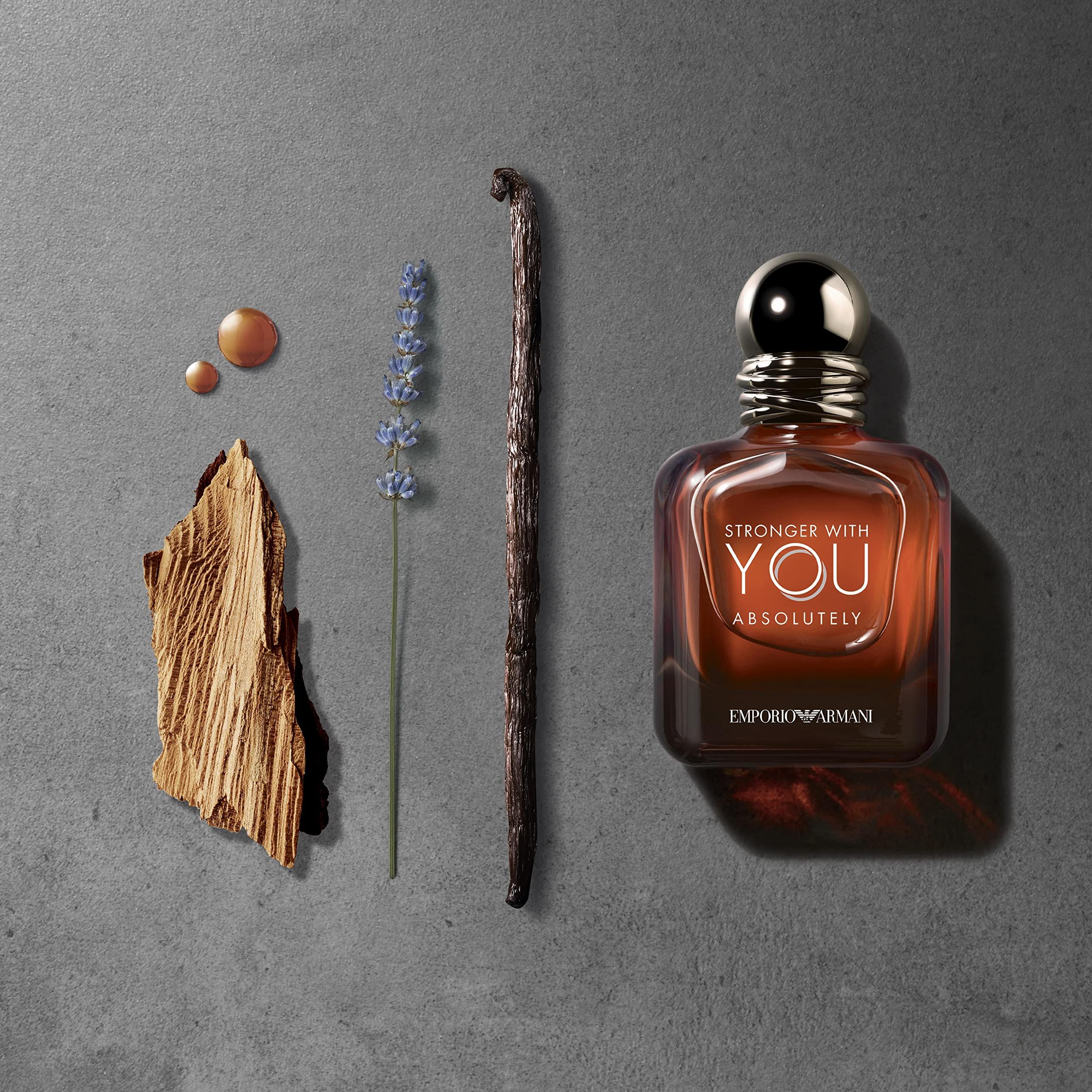 Flacone di profumo accanto a ingredienti: legno, lavanda, baccello di vaniglia, gocce.