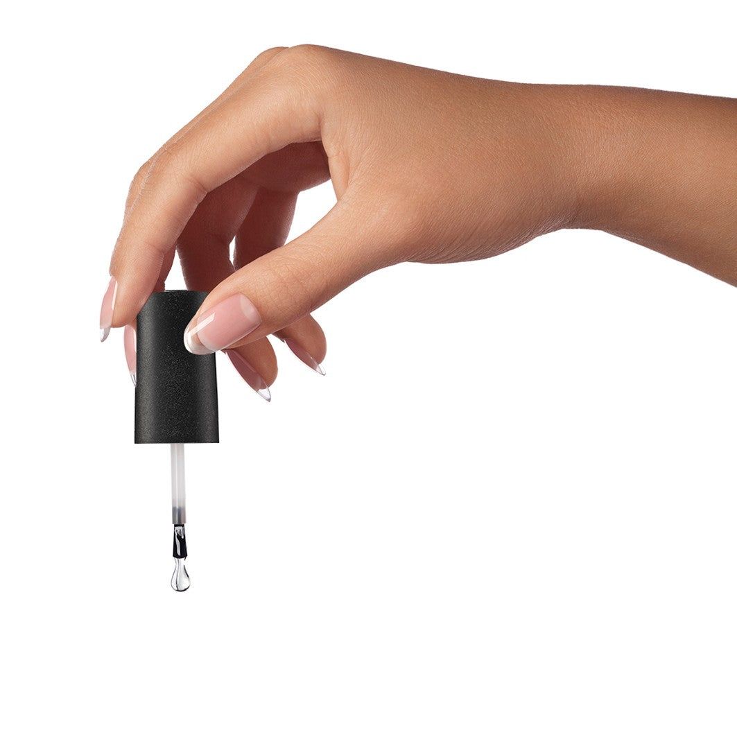 Mano che tiene il pennello di un flacone di gel costruttore LCI Cosmetics Infinity. Goccia di gel sul pennello.