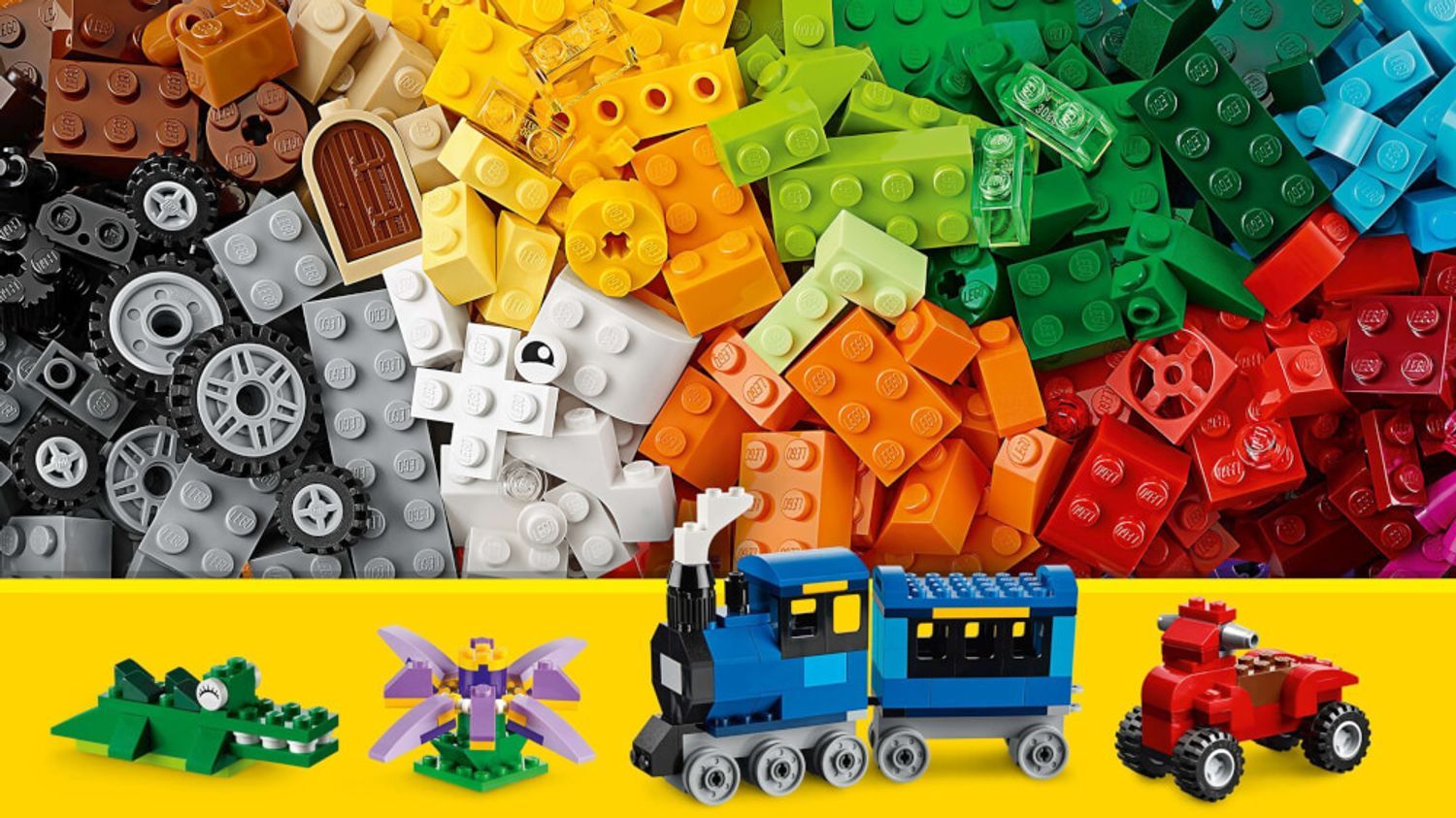 Primo piano di mattoncini LEGO di vari colori. Modelli come treno, auto e personaggi. Mattoncini LEGO.