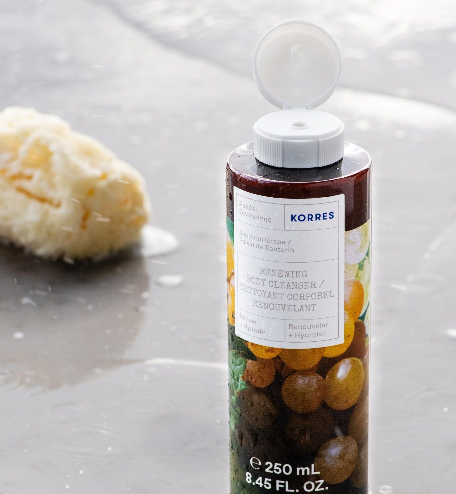 Bagnoschiuma KORRES. Bottiglia con tappo bianco aperto. Etichetta con informazioni sul prodotto e illustrazione di uva. 250 ml.