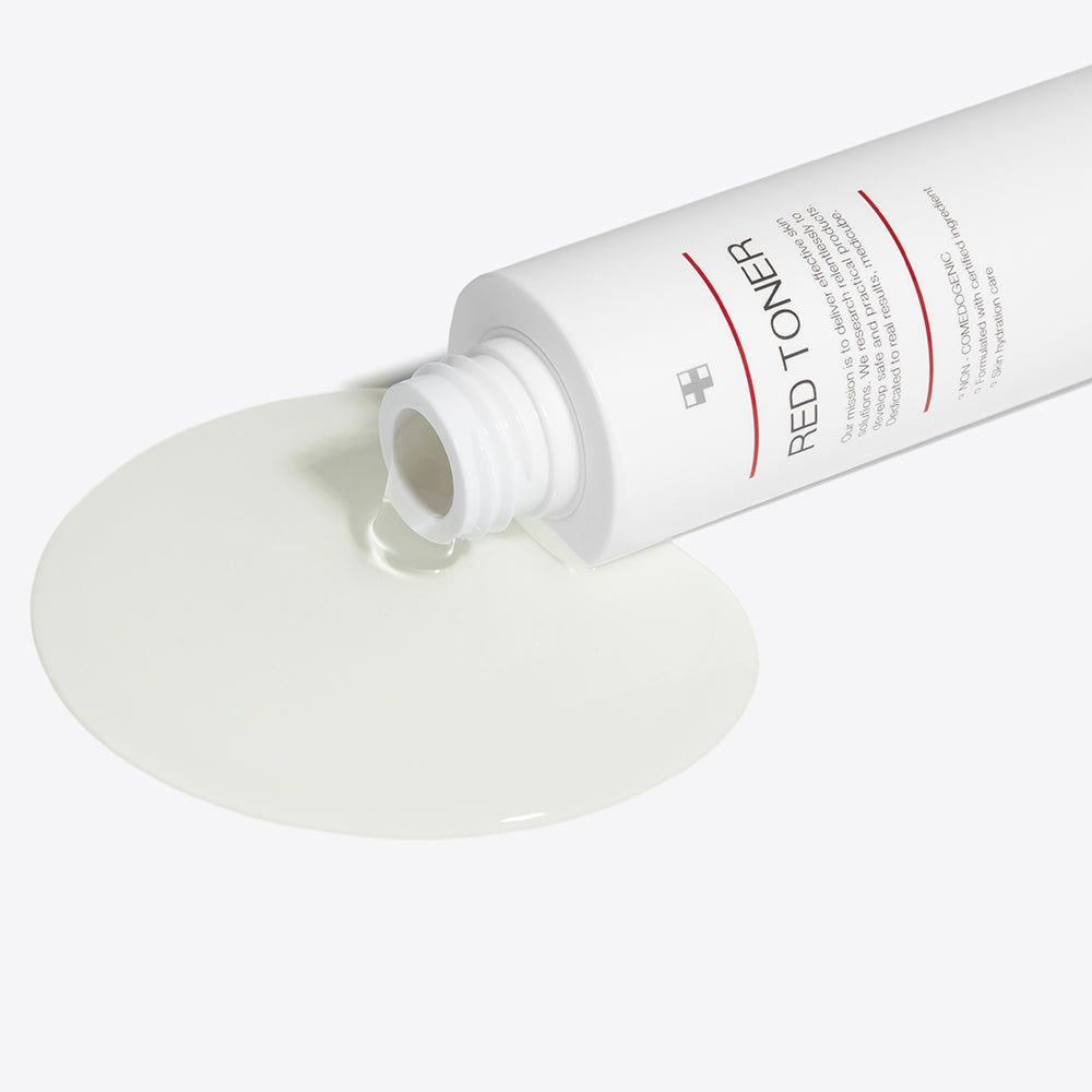 Flacone bianco rovesciato, liquido che fuoriesce. Scritta: RED TONER. Liquido forma una pozza.