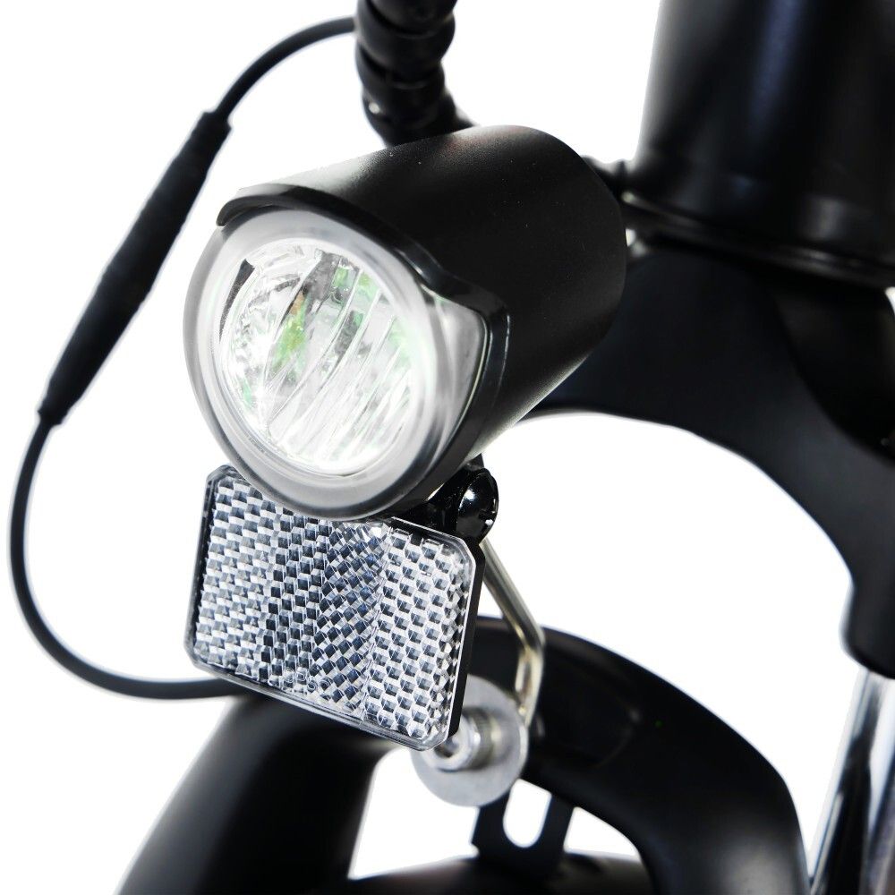 Primo piano del faro e del catarifrangente di una bicicletta elettrica nera.
