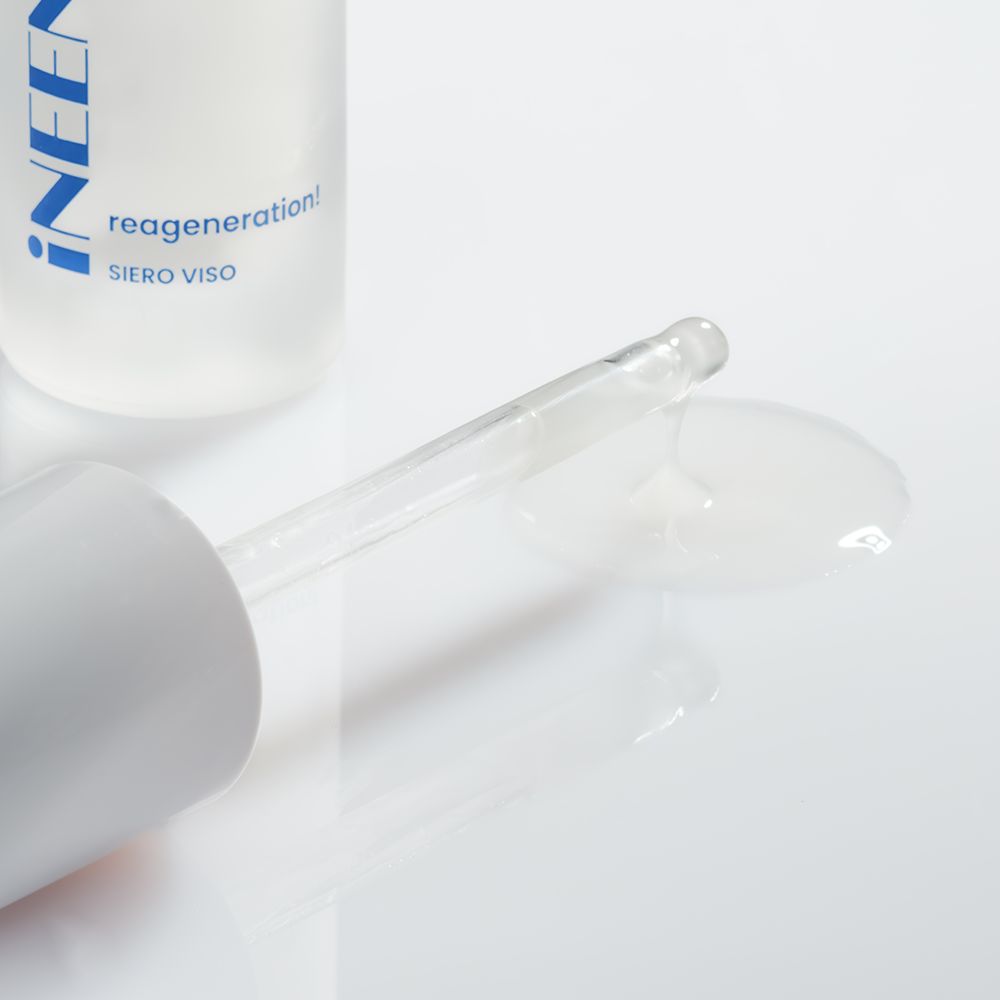 Siero unificante e idratante iNEENOS. con acido ialuronico. Il prodotto è in un flacone bianco con una pompa bianca e una scatola abbinata. La scatola riporta il nome del marchio e le informazioni sul prodotto in blu e pesca.