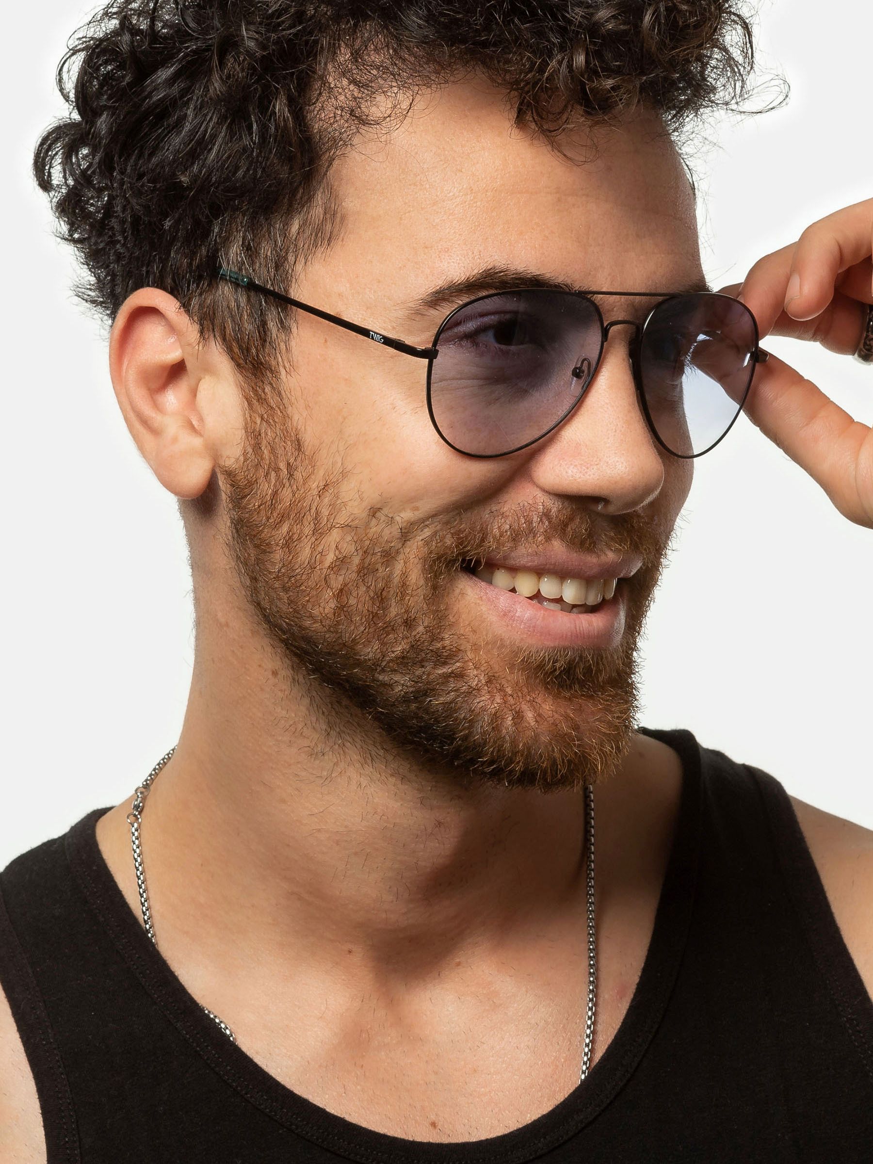 Uomo con occhiali da sole. Montatura nera, lenti blu. Primo piano.