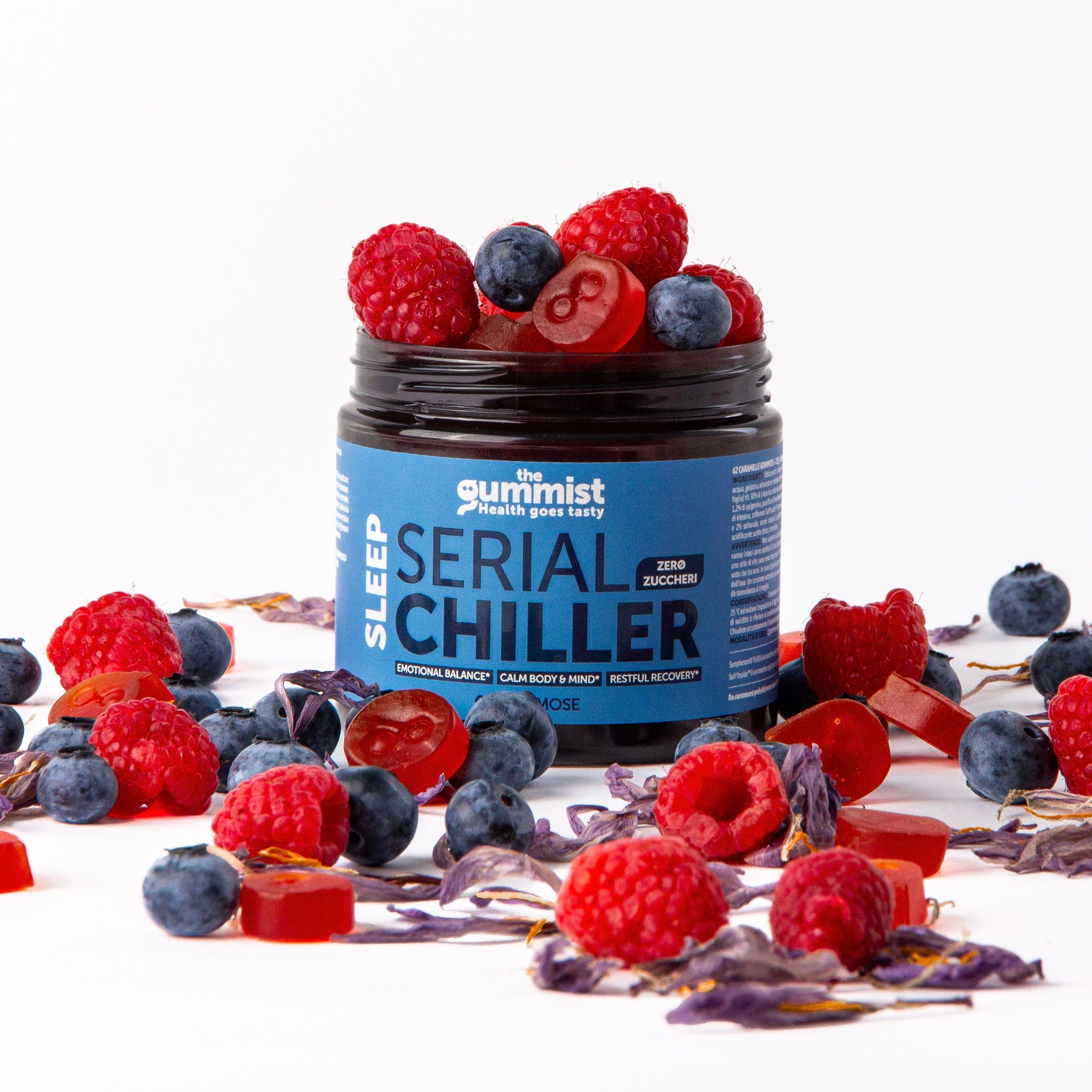 Barattolo scuro con etichetta blu 'Serial Chiller'. Circondato da lamponi, mirtilli e caramelle gommose.