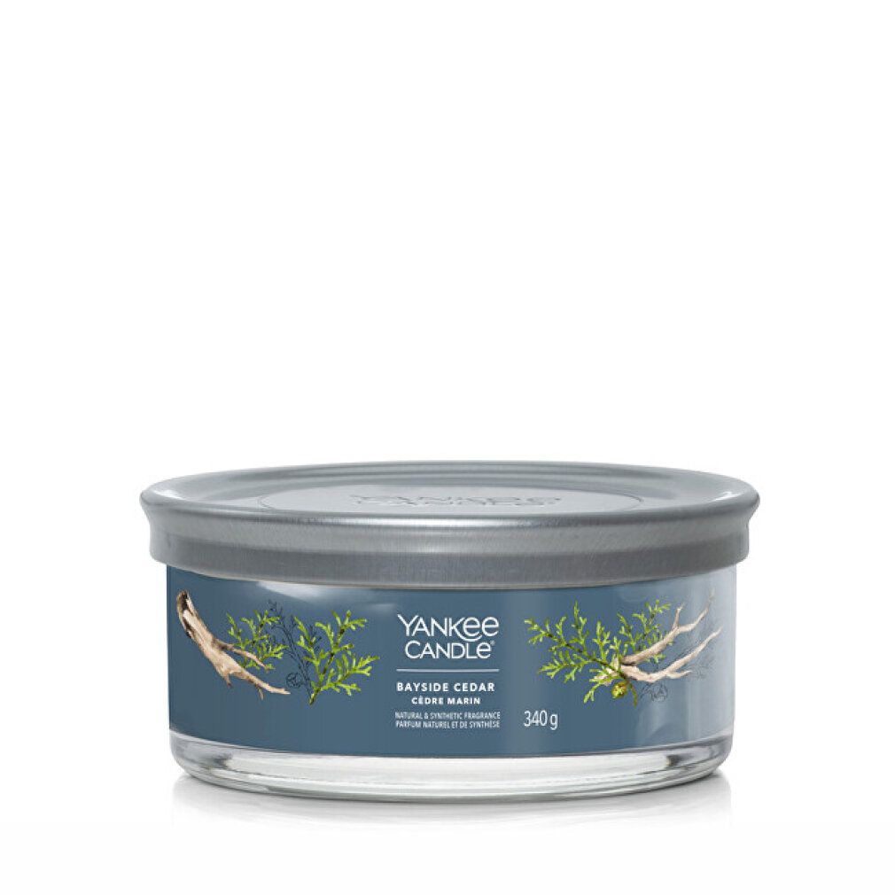 Contenitore rotondo in vetro con coperchio. Scritta: Yankee Candle, Bayside Cedar, Cedre Marin. Illustrazione di rami e legno. 340g.