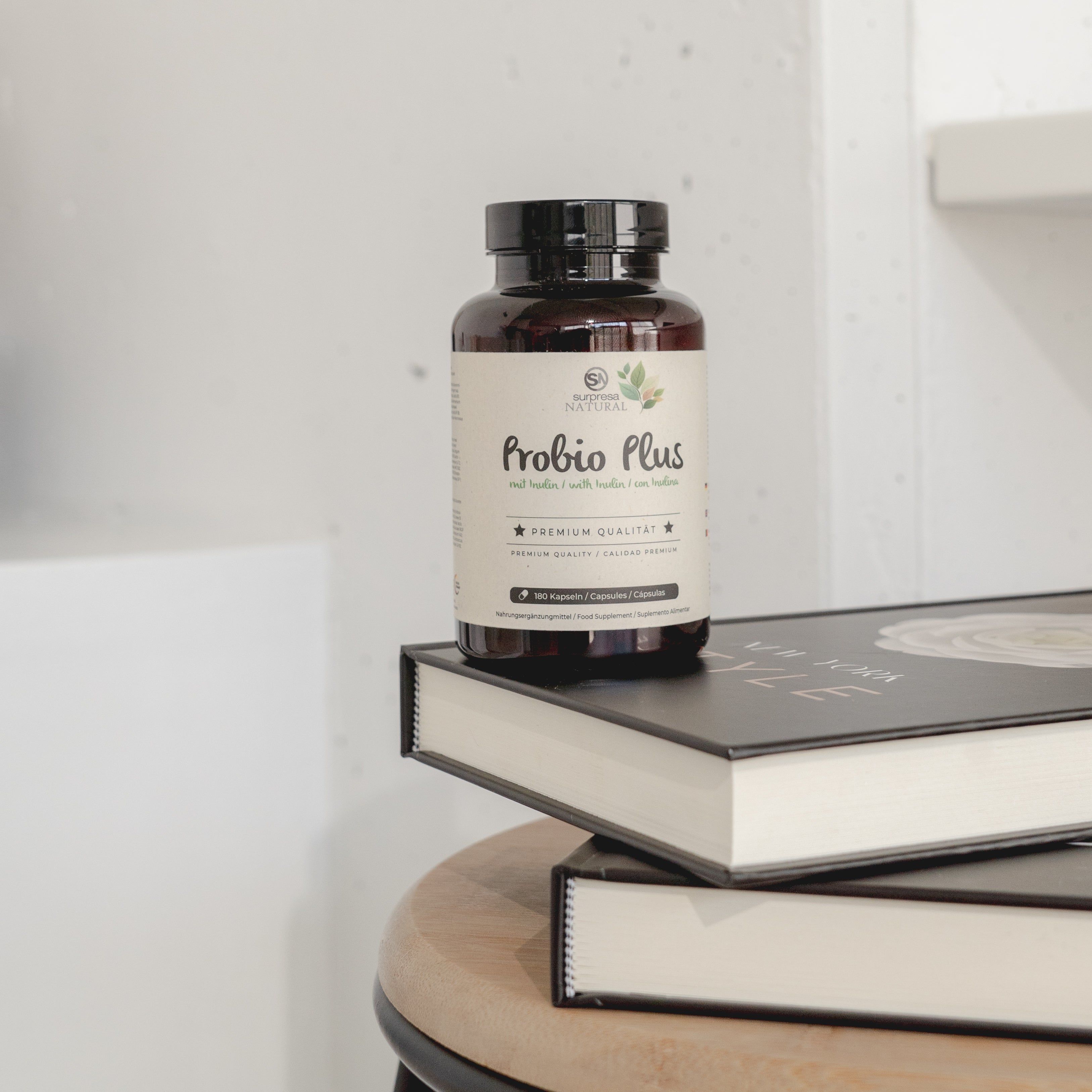 Flacone di capsule Surpresa Natural Probio Plus su due libri.