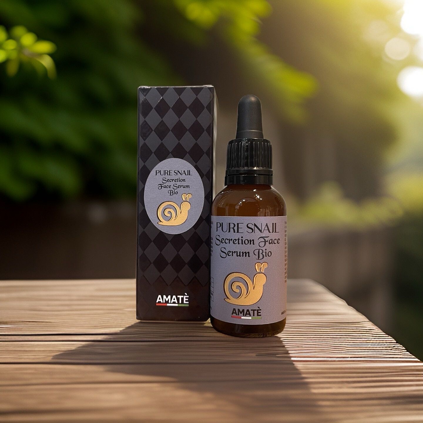 Flacone di vetro marrone con pipetta e scatola su legno. Scritta: Pure Snail Secretion Face Serum Bio. Logo: lumaca. Marchio: Amatè.