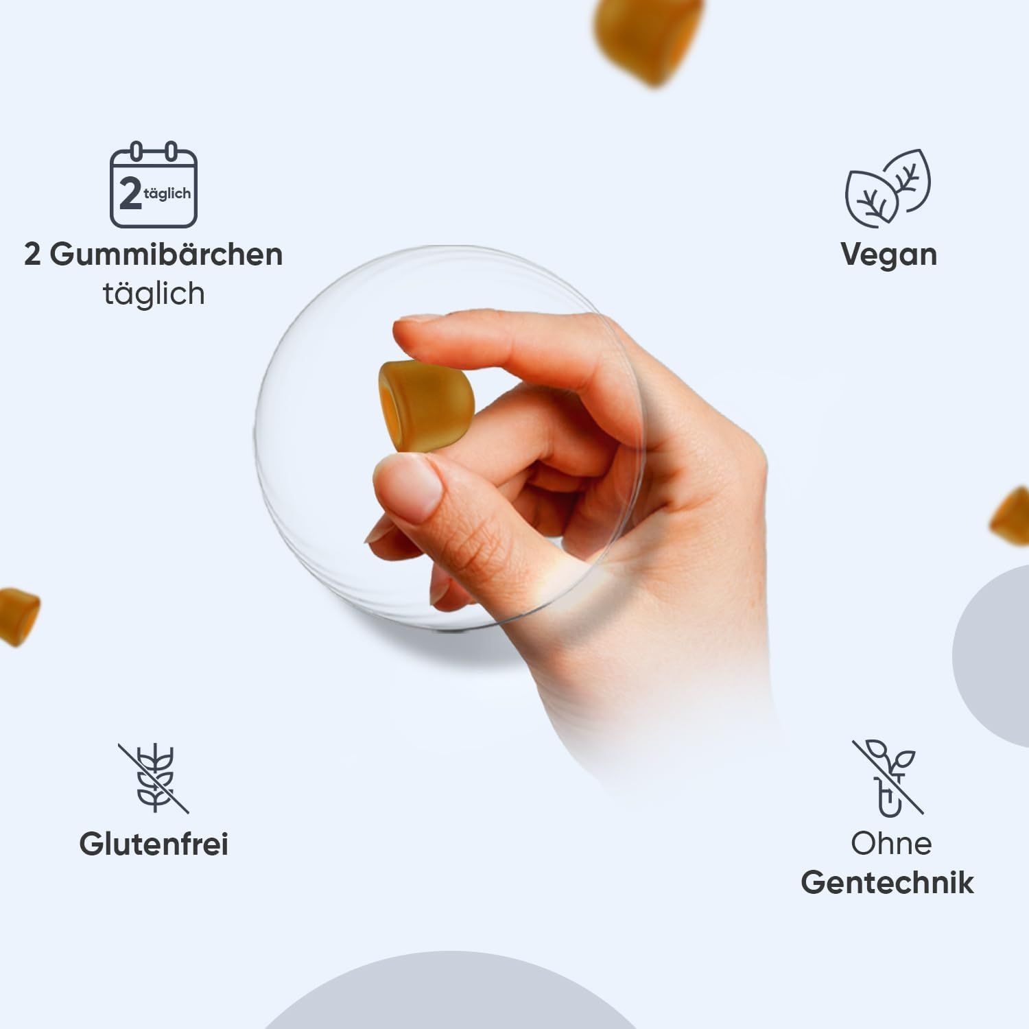 Mano che tiene una caramella gommosa. 2 caramelle gommose al giorno. Senza glutine, vegano, senza OGM.