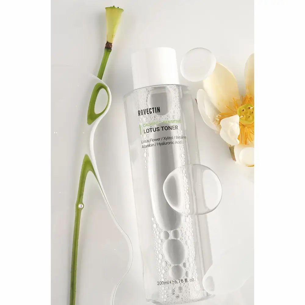 Flacone trasparente con tappo bianco. ROVECTIN Calming Lotus Toner. Fiore di loto e stelo.