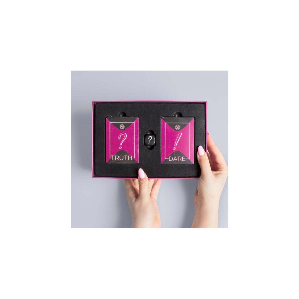 Scatola del gioco "Truth or Dare" aperta con carte e dado. Carte con punti interrogativi ed esclamativi. Elementi rosa e neri.