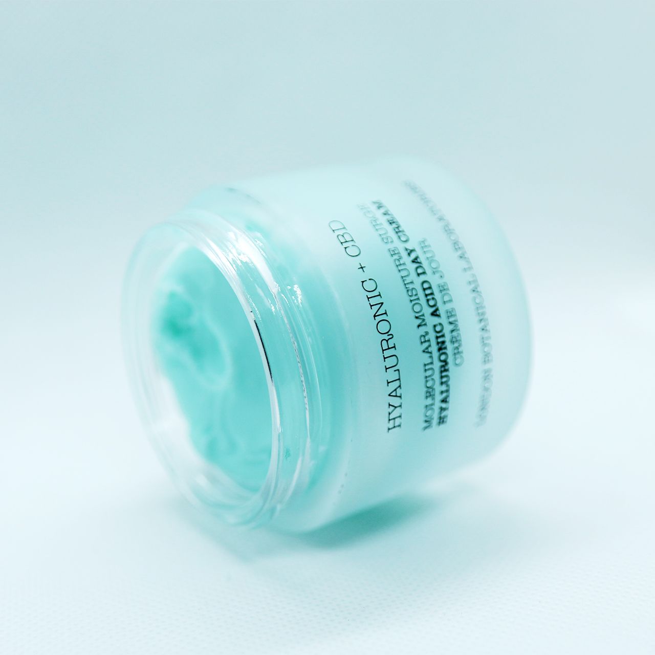 Vasetto inclinato di crema idratante Acido Ialuronico + CBD. Vasetto blu con coperchio argentato.