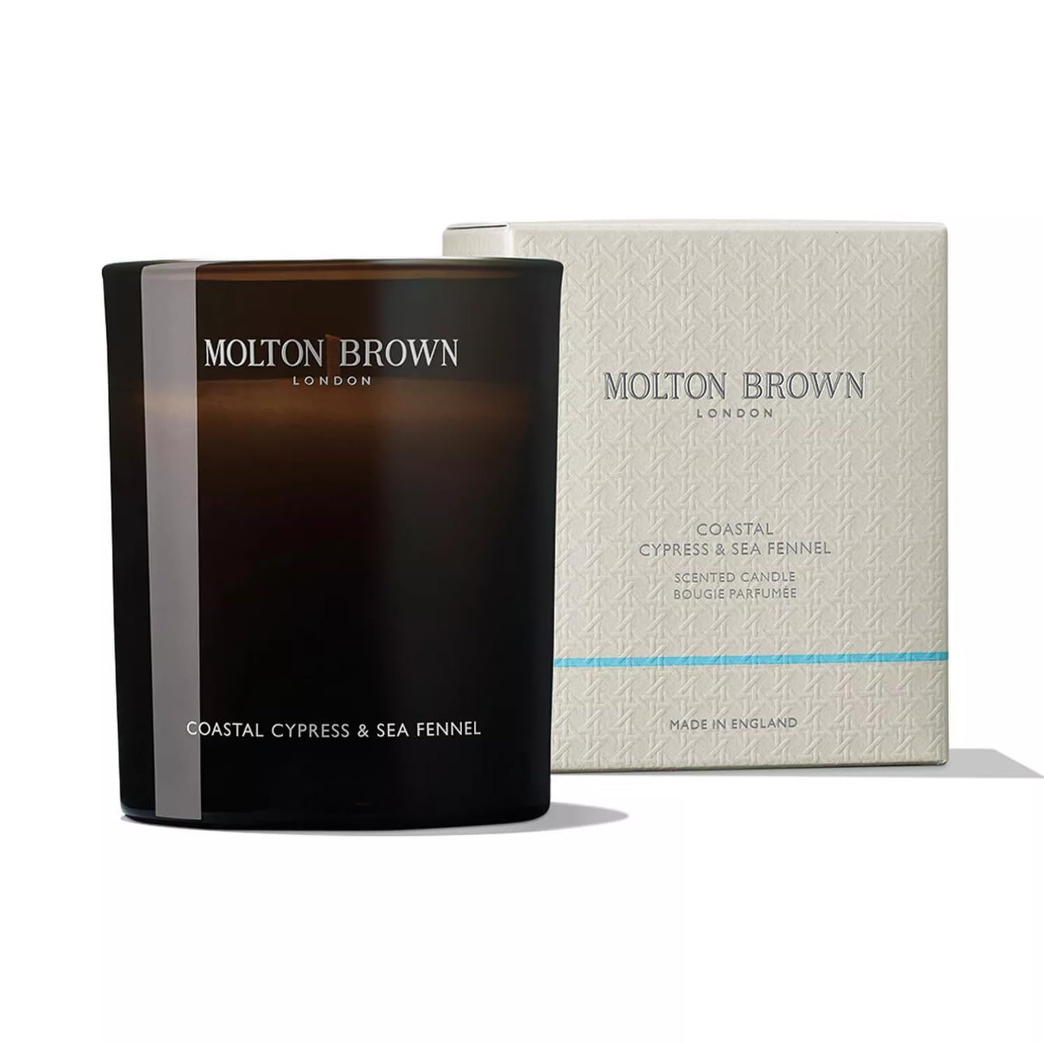 Candela scura e confezione. Scritta: Molton Brown, Coastal Cypress & Sea Fennel. Made in England.
