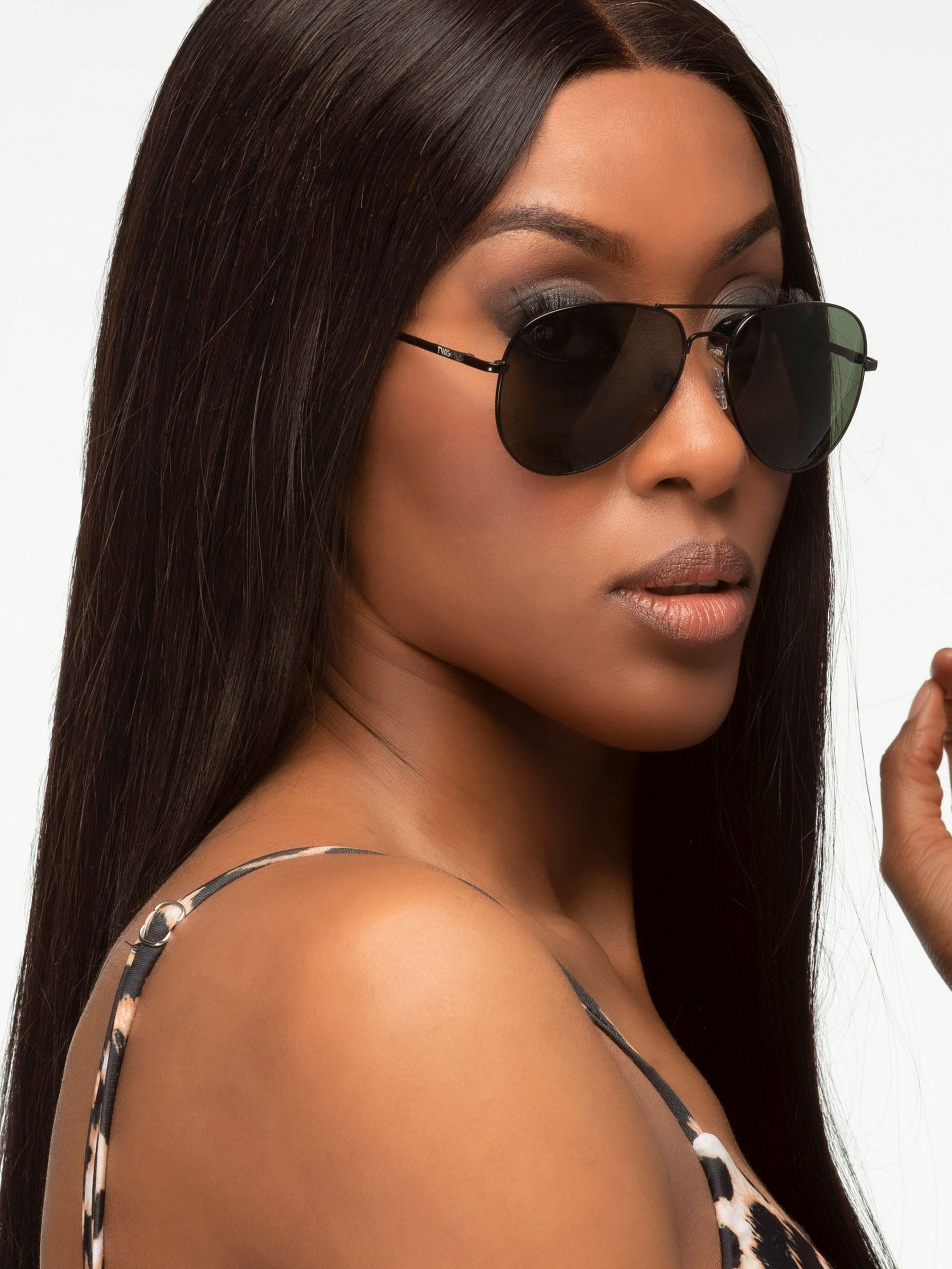 Donna con occhiali da sole Twig, Forest Green. Montatura nera, lenti verdi. Primo piano.