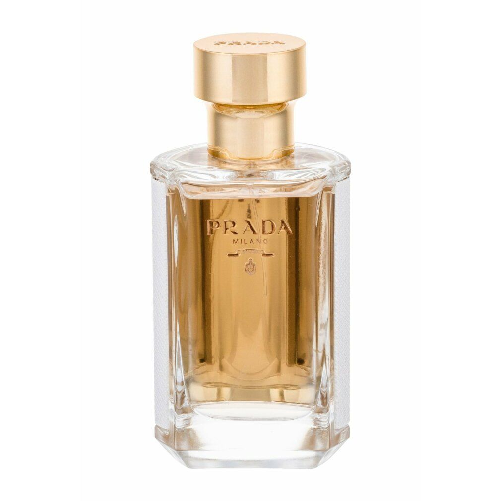 Flacone di profumo con tappo dorato. Scritta: PRADA. Forma rettangolare con interno dorato e motivo bianco sui lati.
