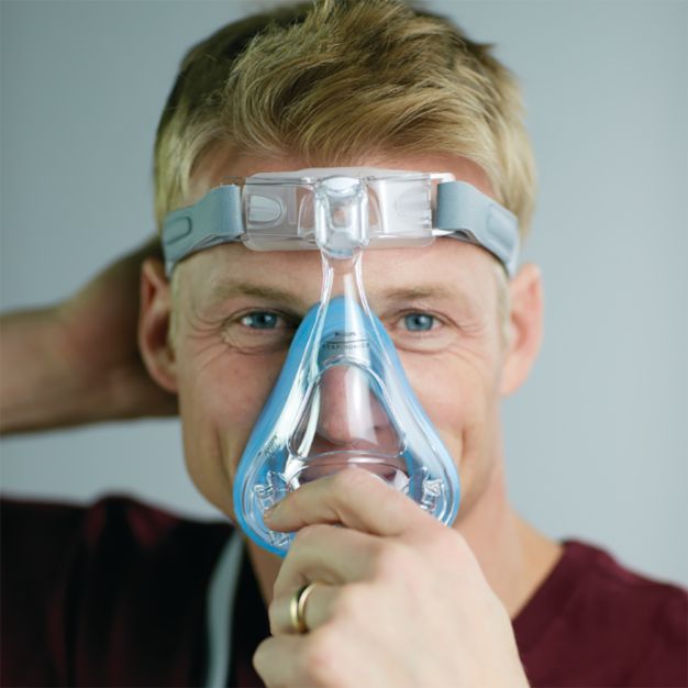 Uomo con maschera CPAP Philips Amara SE Gel Full: maschera naso-bocca indossata.