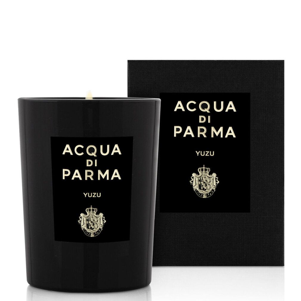 Candela nera con etichetta e confezione nera. Scritta: Acqua Di Parma, Yuzu. Stemma dorato. Forma cilindrica.