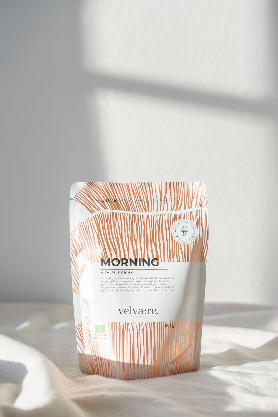 Confezione con scritta: MORNING Vitalpilz Drink, velvaere. Motivo di sfondo. Marchio di certificazione.