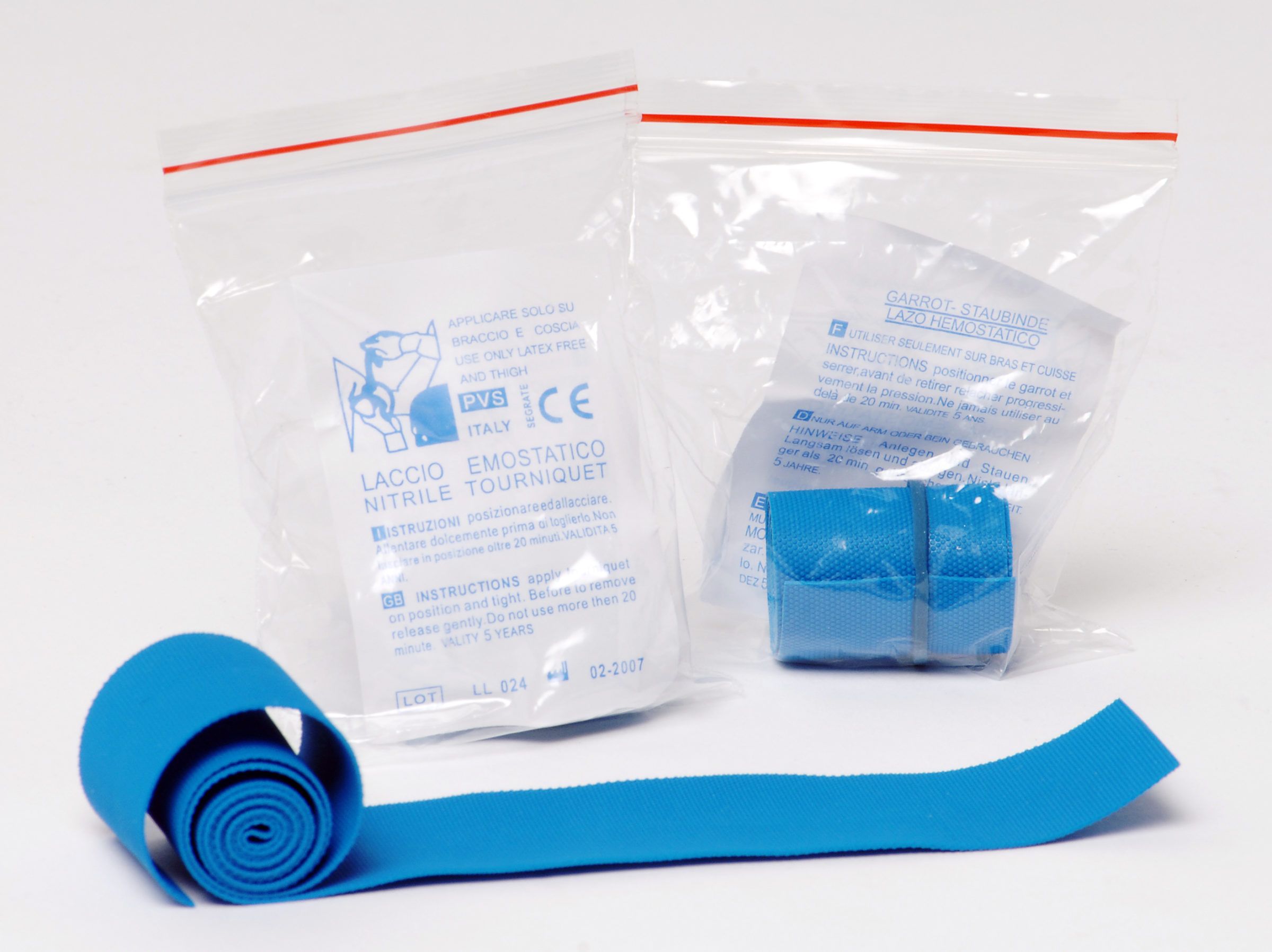 Laccio emostatico blu parzialmente srotolato, con confezioni trasparenti.