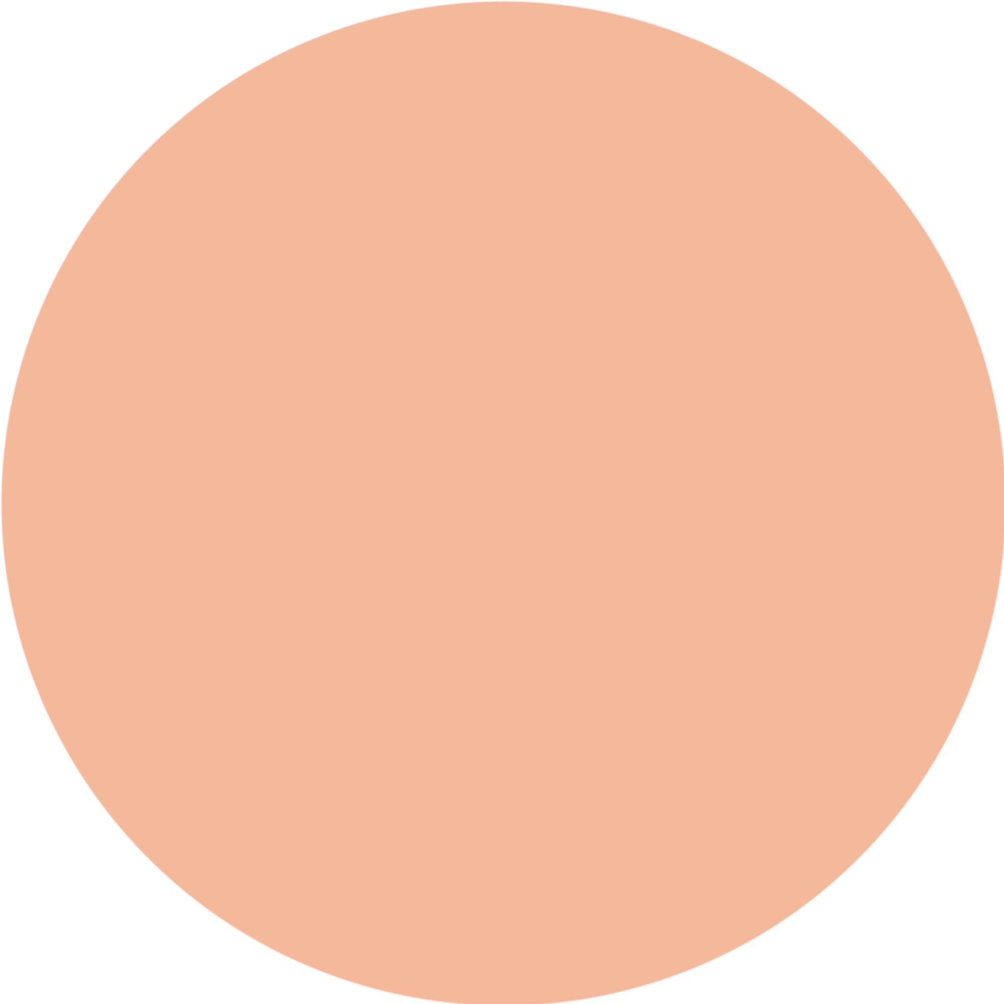 Un cerchio di colore beige medio. Il colore è uniforme e coprente. La tonalità suggerisce un correttore o un prodotto cosmetico simile, adatto agli incarnati con sfumature calde.