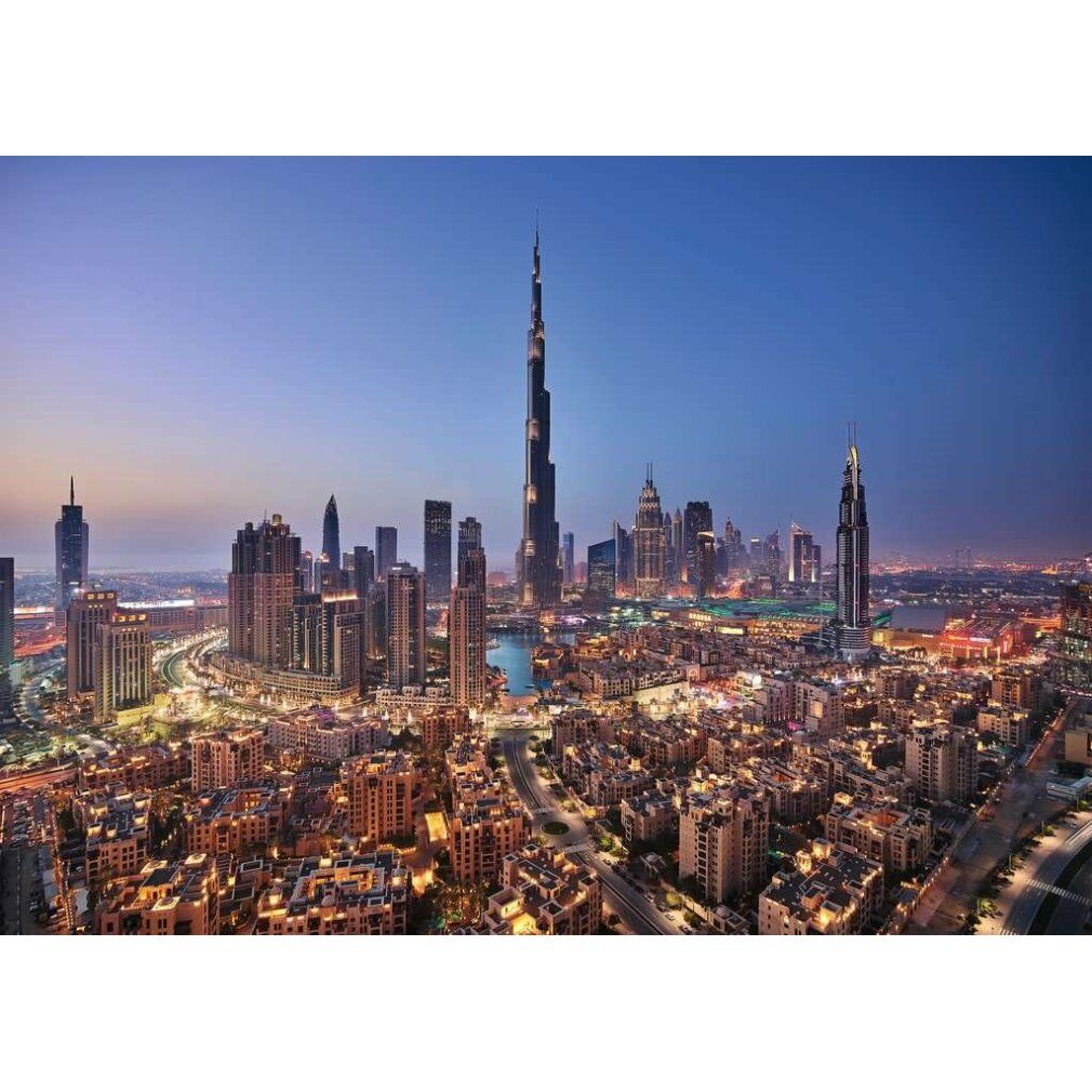 Panorama di Dubai notturna. Edifici alti e grattacieli, tra cui il Burj Khalifa, illuminati. Paesaggio urbano con strade e acqua.