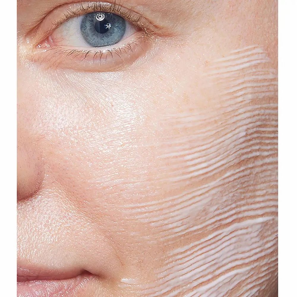 Primo piano di un viso con crema applicata. La crema è applicata a strisce.