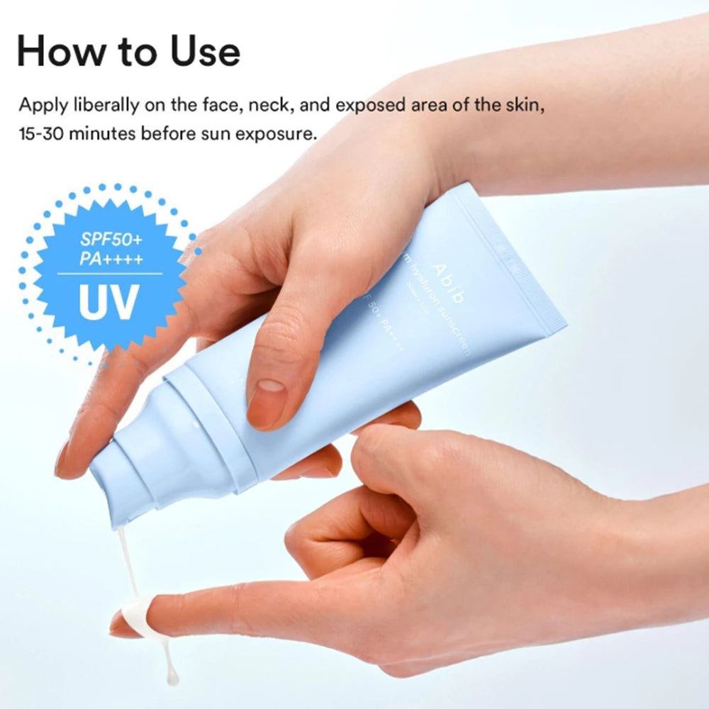 Mani che tengono un tubetto azzurro di crema solare Abib Sedum Hyaluron mentre la crema viene applicata su un dito.