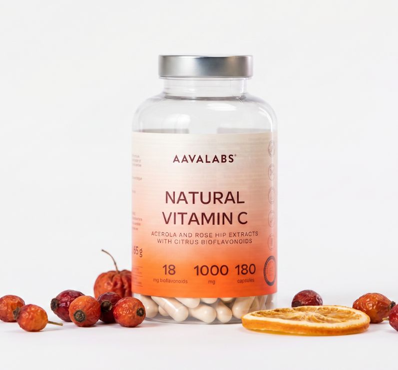 Flacone di Aavalabs Vitamina C Naturale 1000 mg, circondato da bacche di rosa canina e una fetta d'arancia.