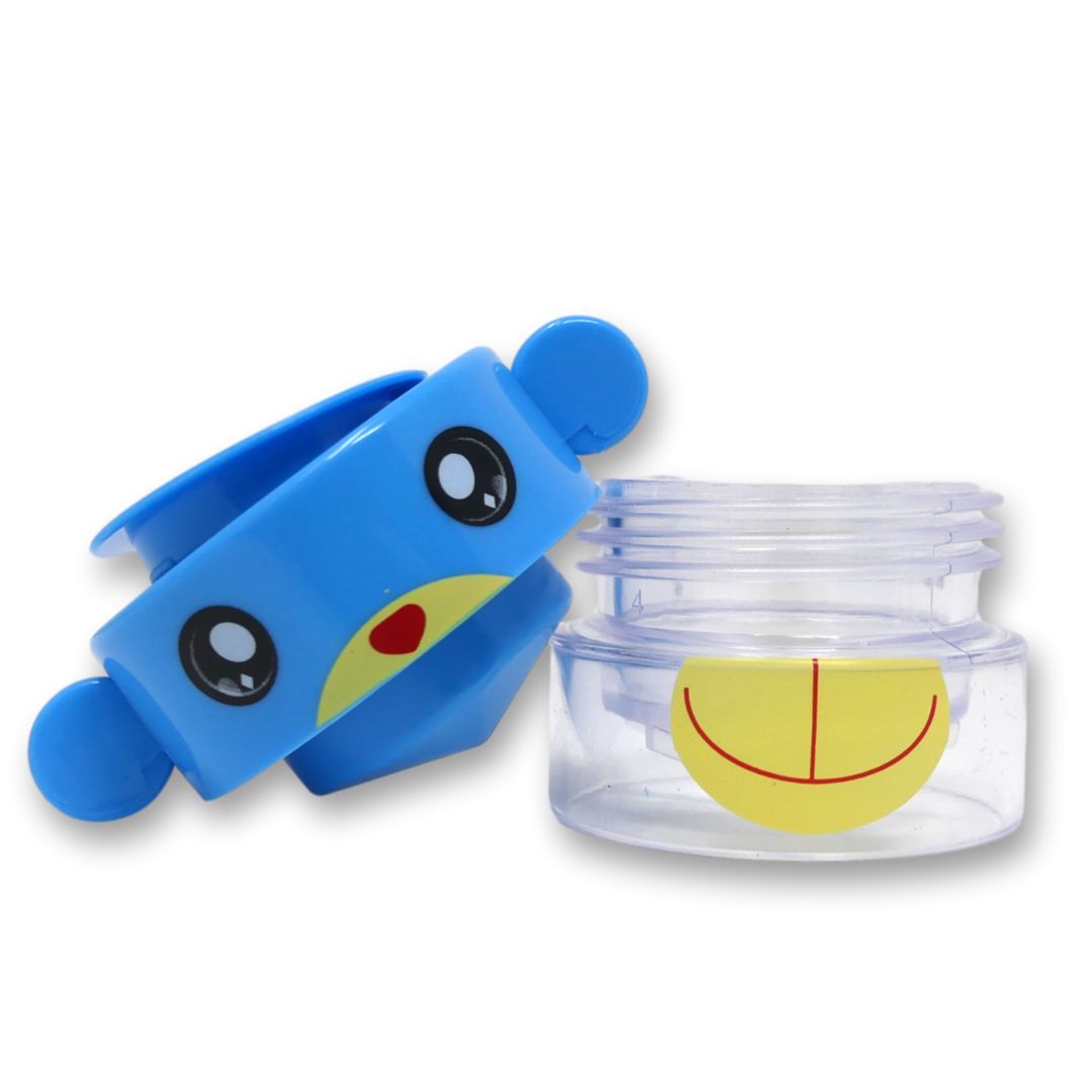 Mortaio per compresse blu con design a scimmia, smontato. Coperchio con orecchie e viso, contenitore con bocca gialla. Logo LisaCare.