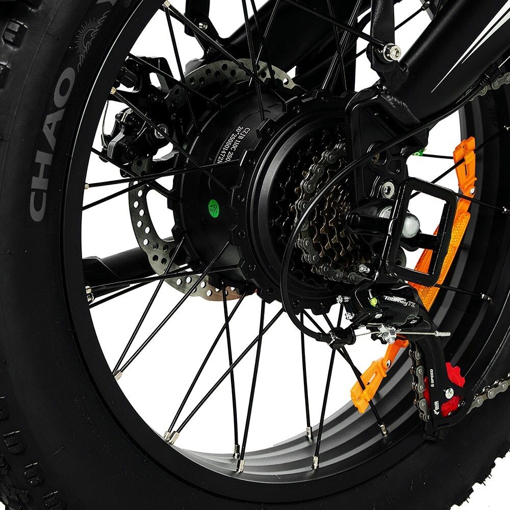 Primo piano della ruota posteriore di una e-bike. Motore, cambio e freno a disco visibili. Pneumatici neri.