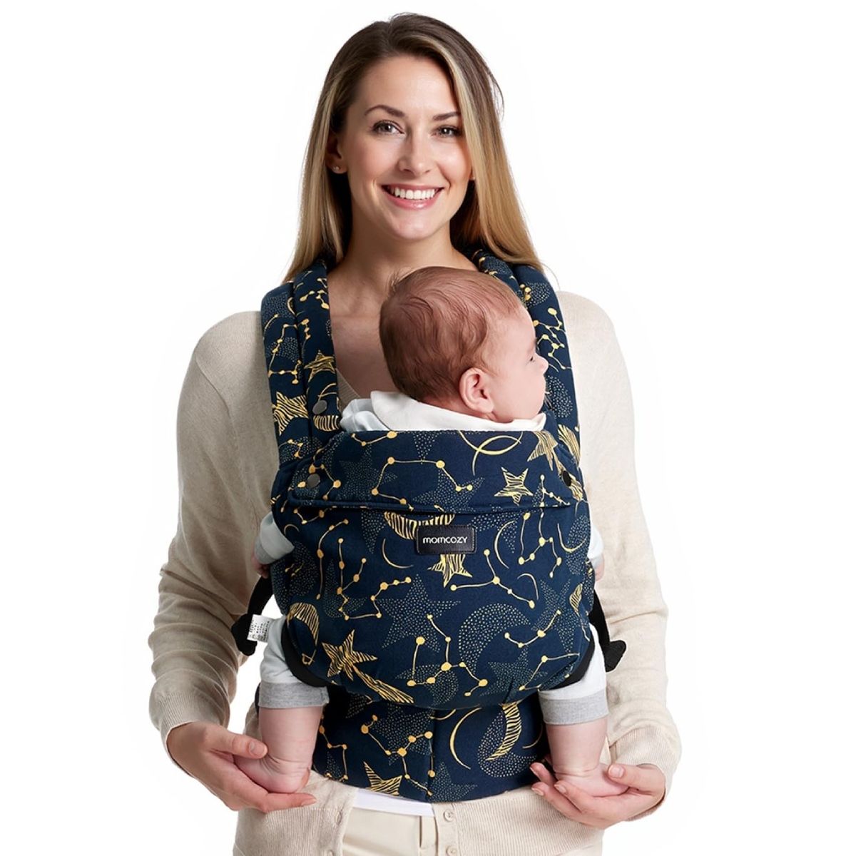 Donna tiene neonato in marsupio con stelle. Bambino guarda avanti. Logo Momcozy visibile.