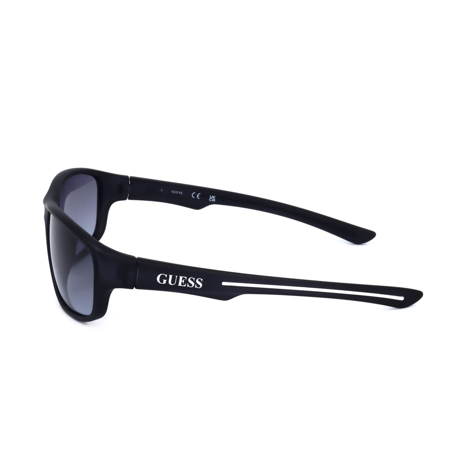 Occhiali da sole Guess neri con lenti sfumate e logo sul
terminale.