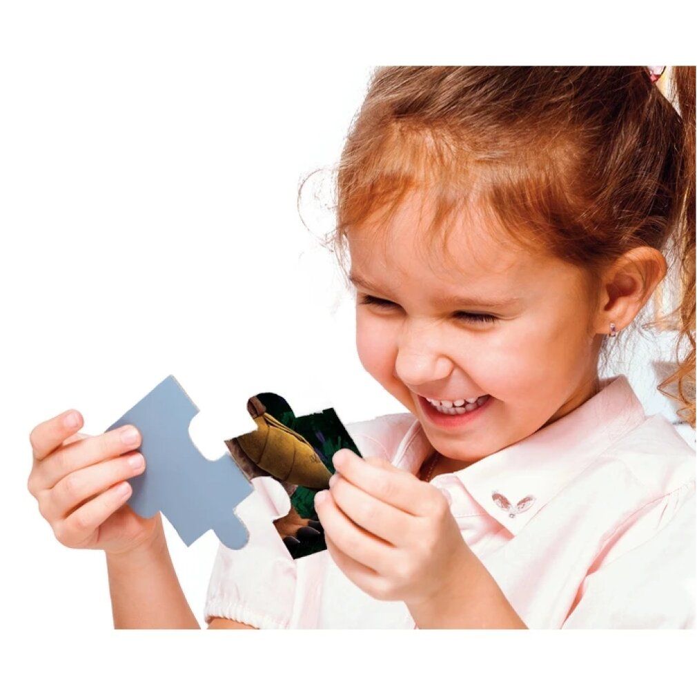 Bambina tiene un pezzo di puzzle con Raya, l'ultimo drago. Pezzo di puzzle grigio accanto. Puzzle Clementoni.