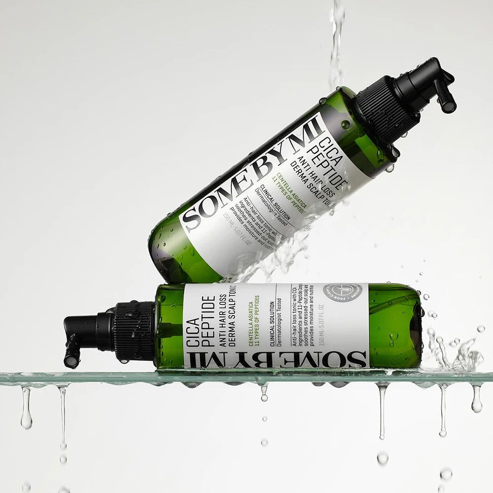 Due flaconi verdi con erogatore nero. Scritta: Cica Peptide Anti Hair Loss Derma Scalp Tonic. Marchio: SOME BY MI. Spruzzi d'acqua.